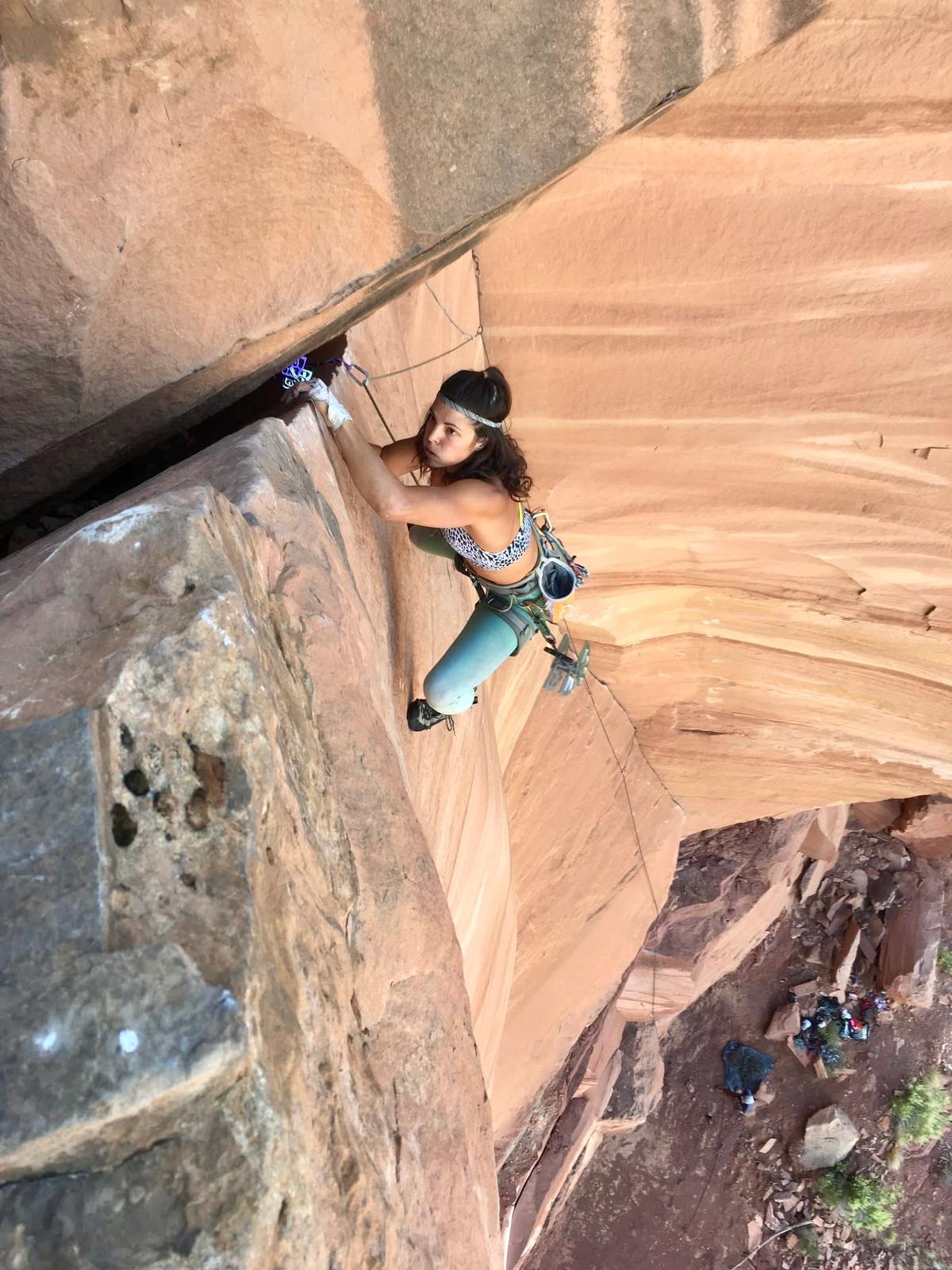 Escaladora en pared natural durante una ruta de escalada deportiva